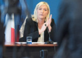 Marine Le Pen looks serious at press conference table